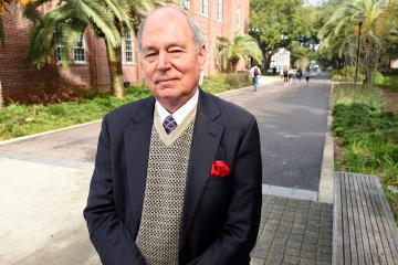 Close-up of Eric Smith standing in front of a building, with the structure's details slightly blurred in the background.